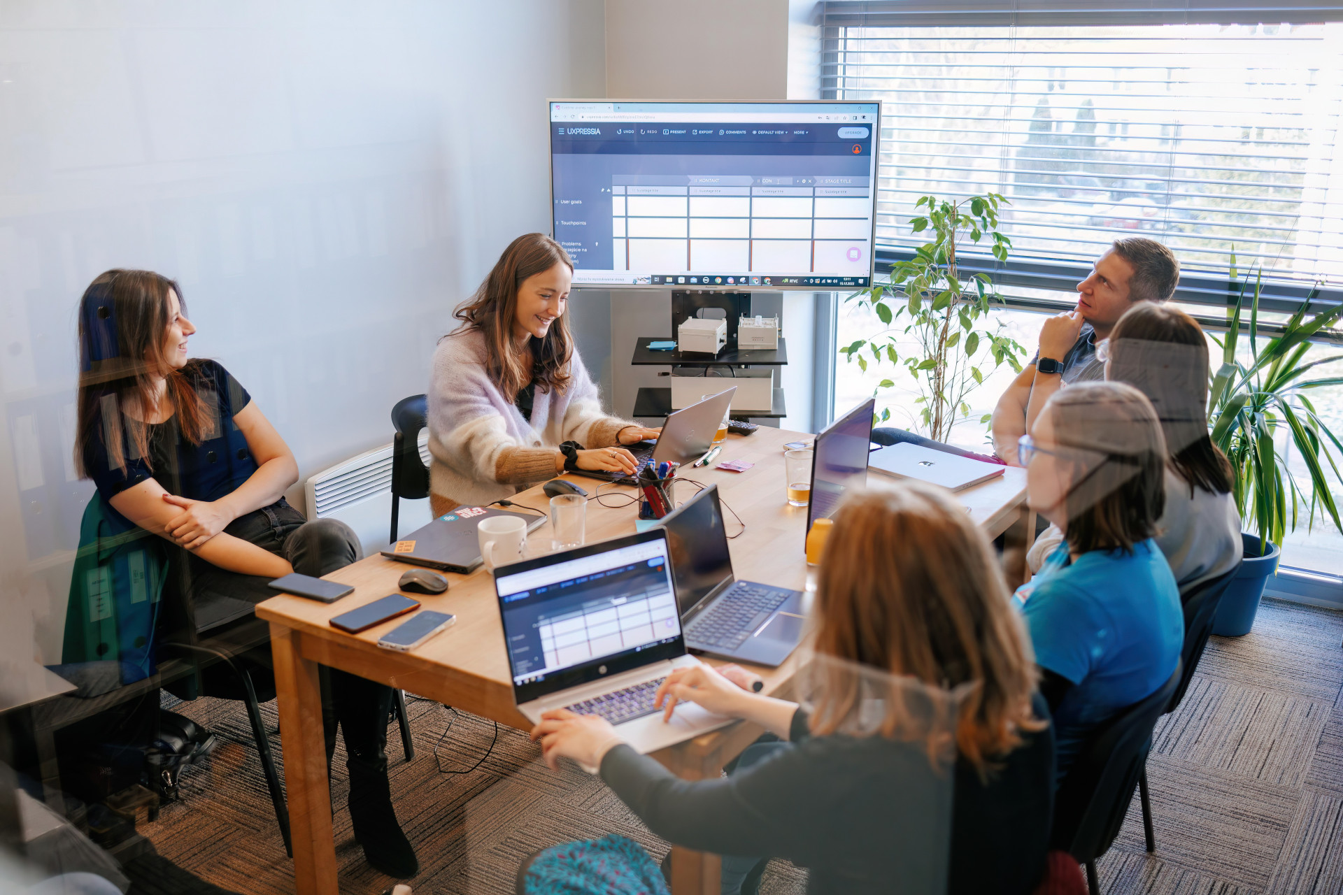 Engineering team collaborating in a workshop session with laptops and shared screen